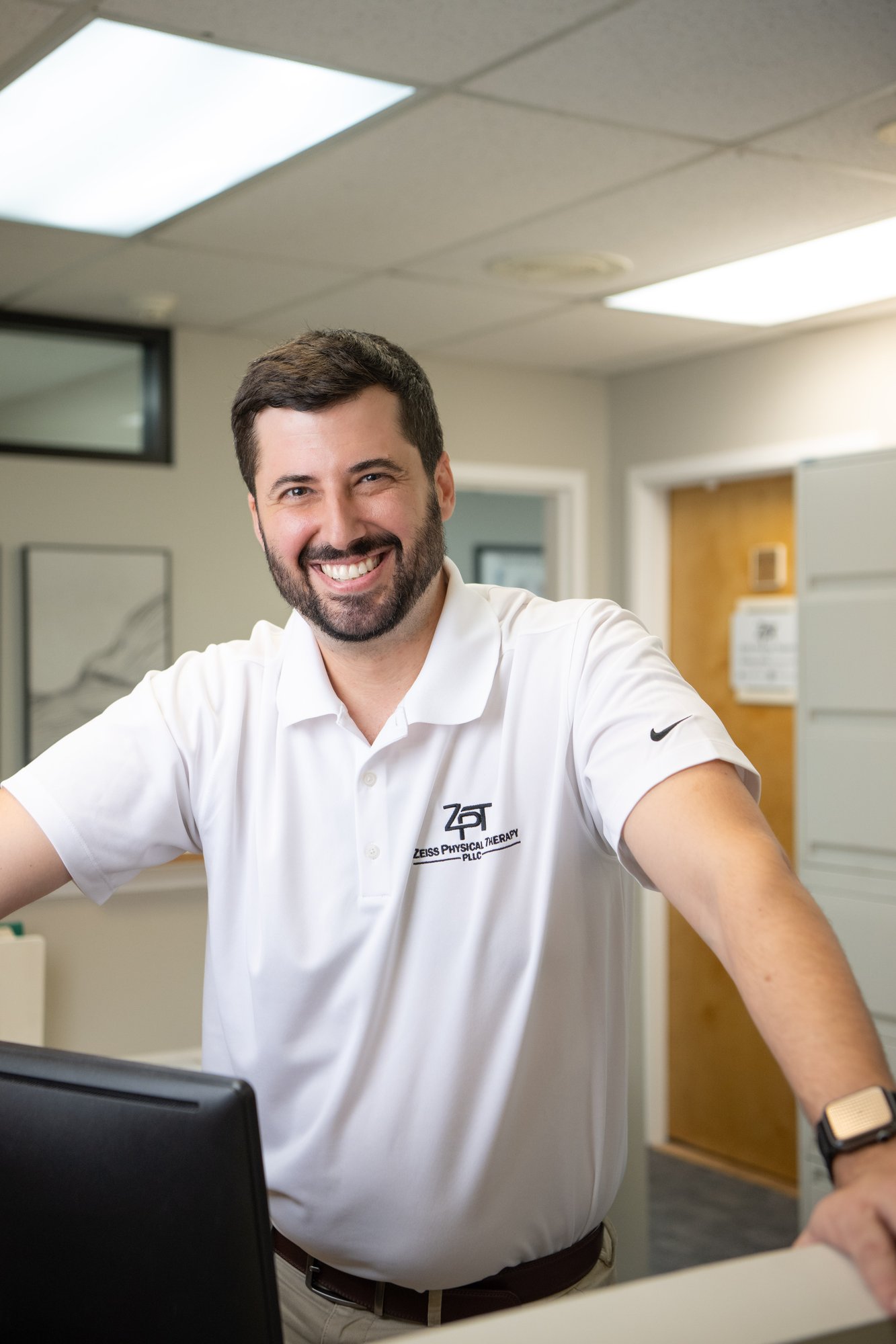 Russell Zeiss, DPT, founder of Zeiss Physical Therapy, at the front desk of the Somers, NY clinic